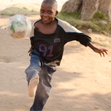 Child at Musha Wevana children's home in Marondera, Zimbabwe, kicking one of their old "soccer balls" made from plastic bags.